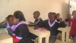 Thomas Odhiambo(touching his head)with his classmate in class six at Cana centre